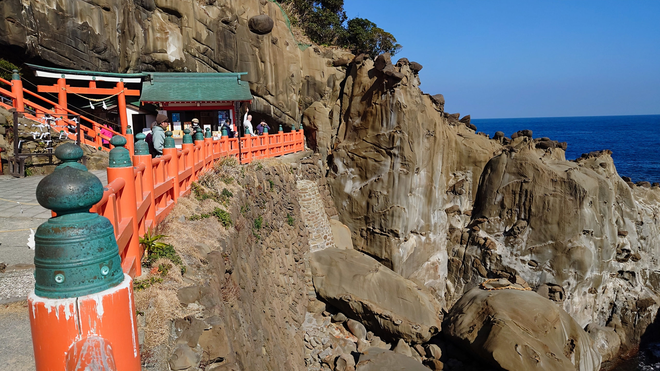 鵜戸神宮の断崖沿いに続く朱色の手すりと亀石、青い海のコントラスト