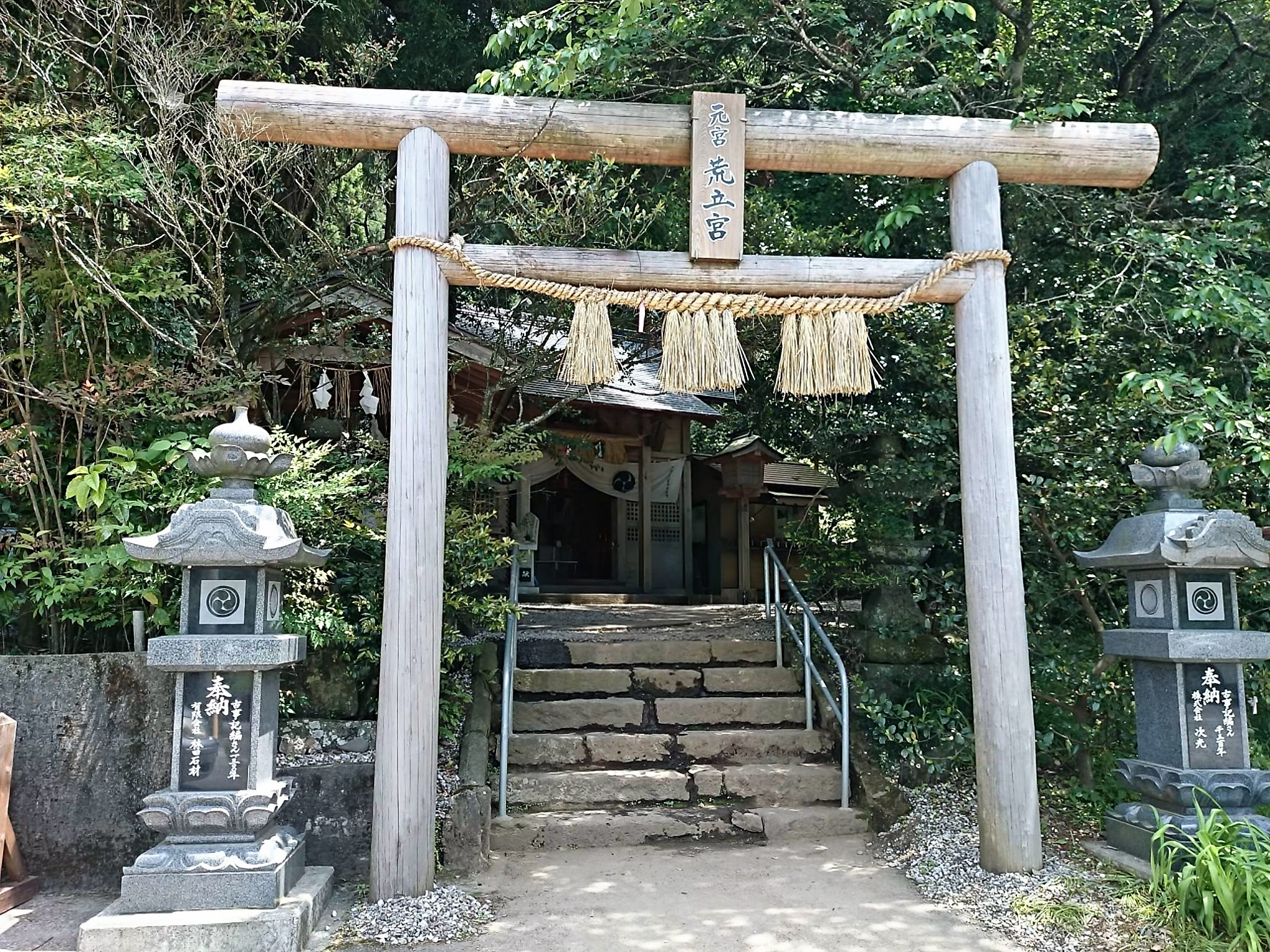 荒立神社の境内入口に建つ木製鳥居と石灯籠
