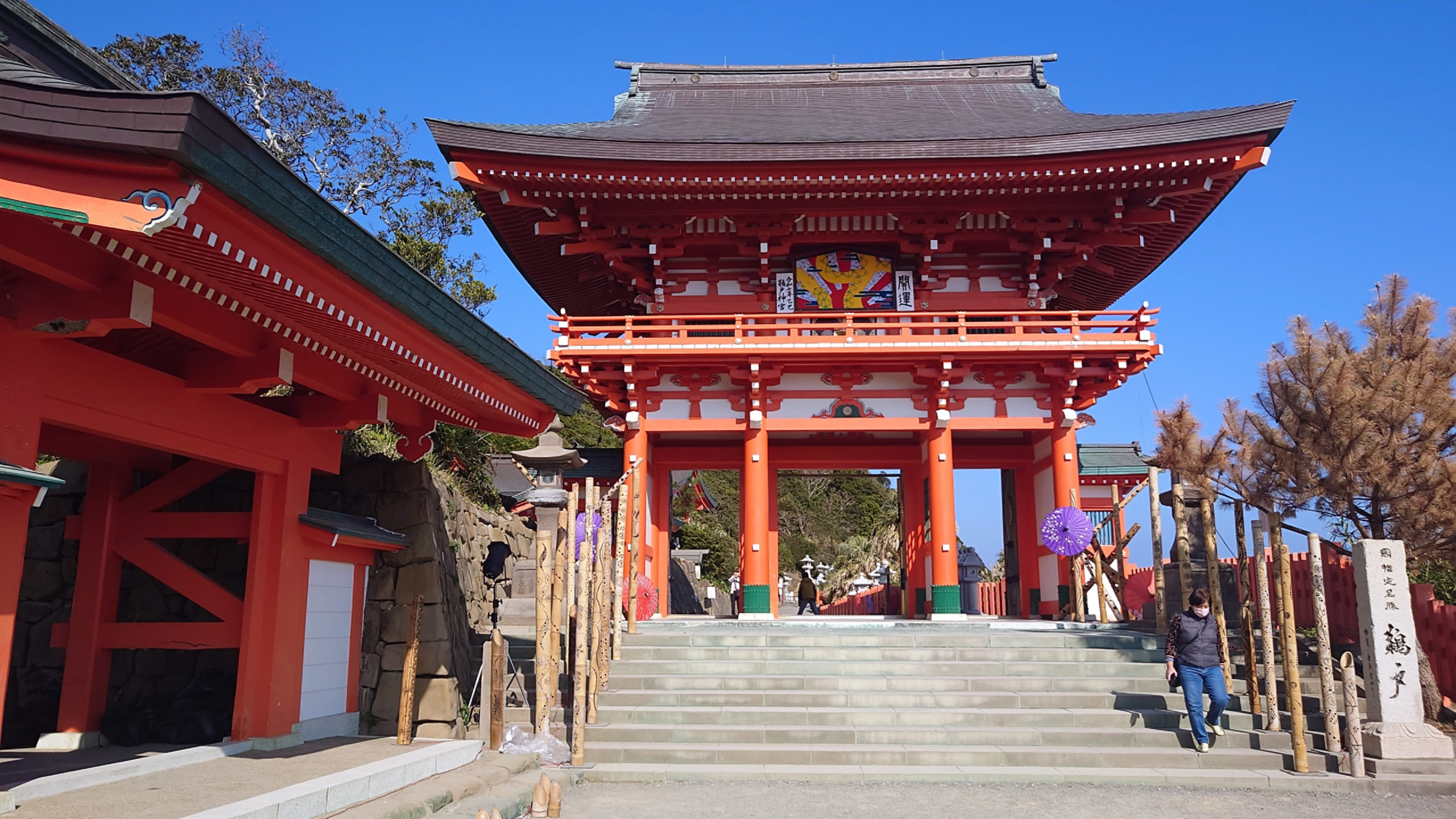 鵜戸神宮の朱塗りの楼門を正面から撮影、背後に南国の木々と青空