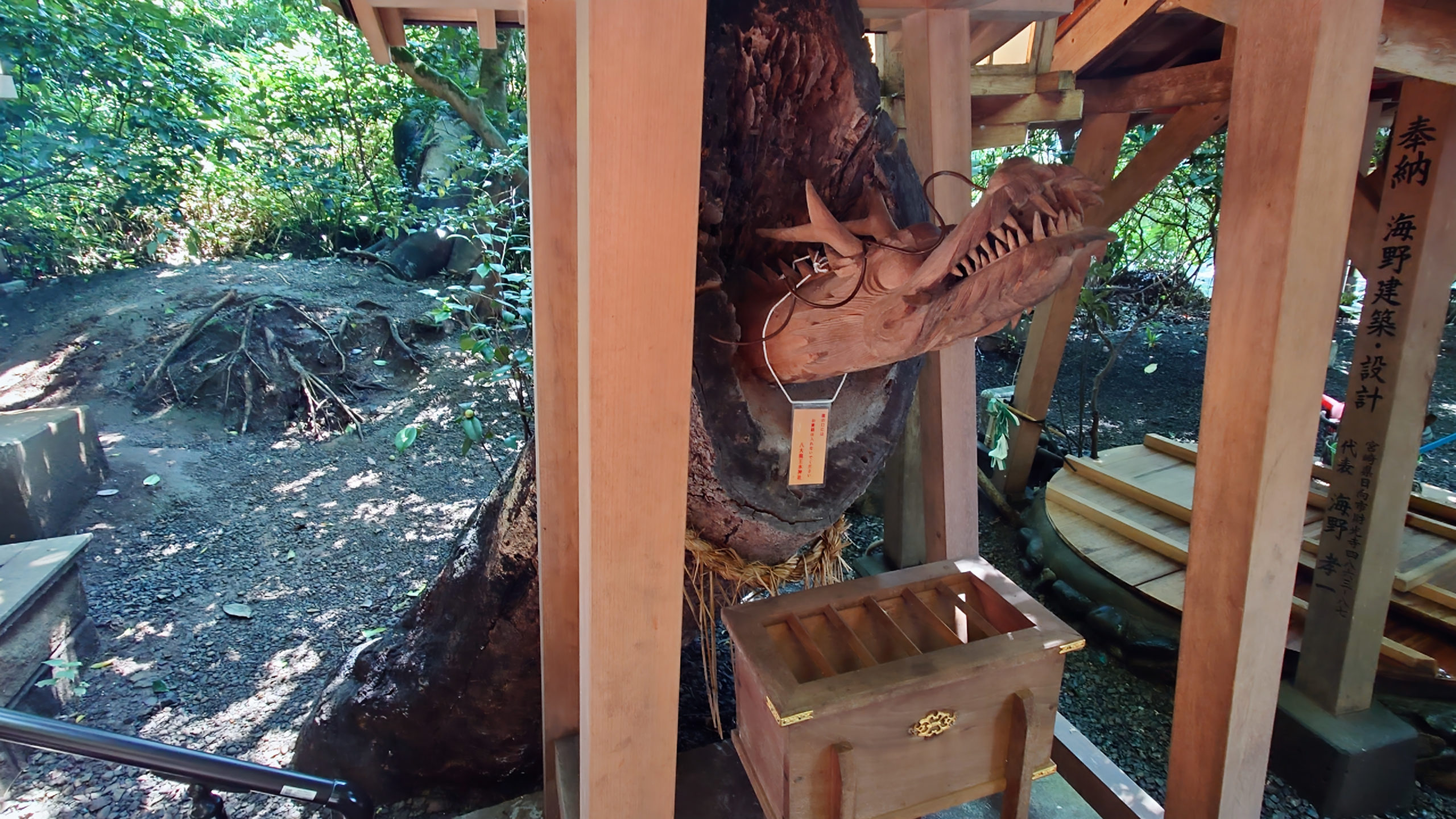 かつての御神木の切り株に彫られた龍の彫刻。小さな祠として祀られている
