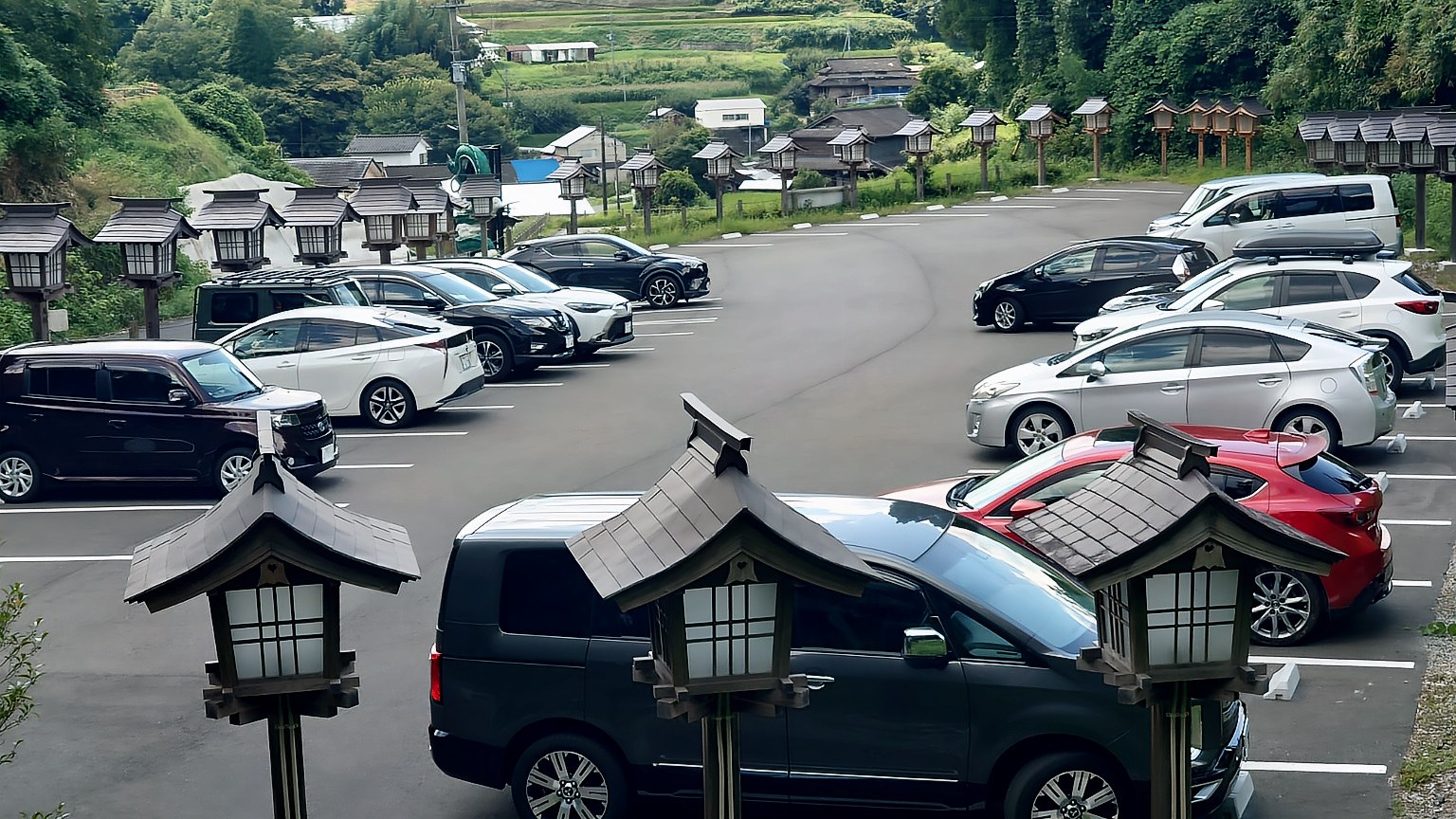 朔日参り（2025-09-01）の駐車場の様子。常に20台程度の車が駐車し、ひっきりなしに参拝者の車が入れ替わっている。